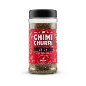 Bottle of Al Frugoni Spicy Chimichurri Sauce with fresh herbs and chili peppers around it