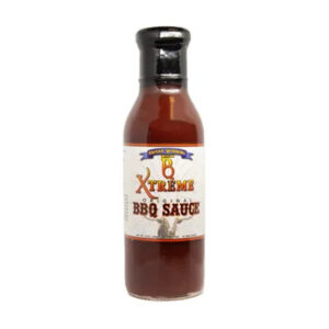 Bottle of B Xtreme BBQ Original Sauce with ribs and grilled chicken on a cutting board