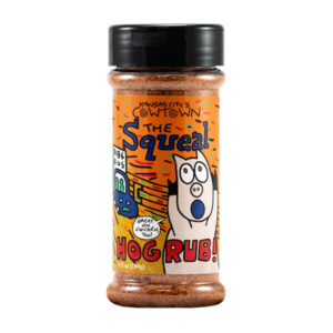 Bottle of Cowtown The Squeal Hog Rub next to grilled ribs and pulled pork