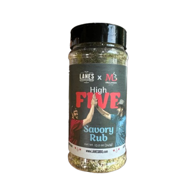 Lane’s McLemore Boys High Five Savory Rub jar beside grilled steak and roasted vegetables.
