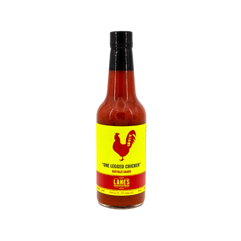 Lane’s One Legged Chicken Buffalo Sauce bottle beside crispy buffalo wings and celery.