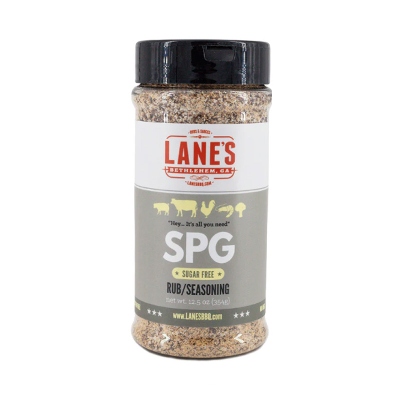 Lane’s SPG Rub jar beside grilled steak and coarse salt and peppercorns.