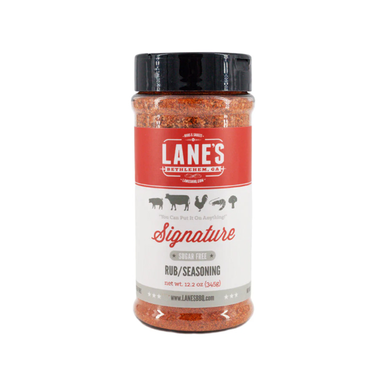 Lane’s Signature Rub jar beside smoked ribs and grilled vegetables.