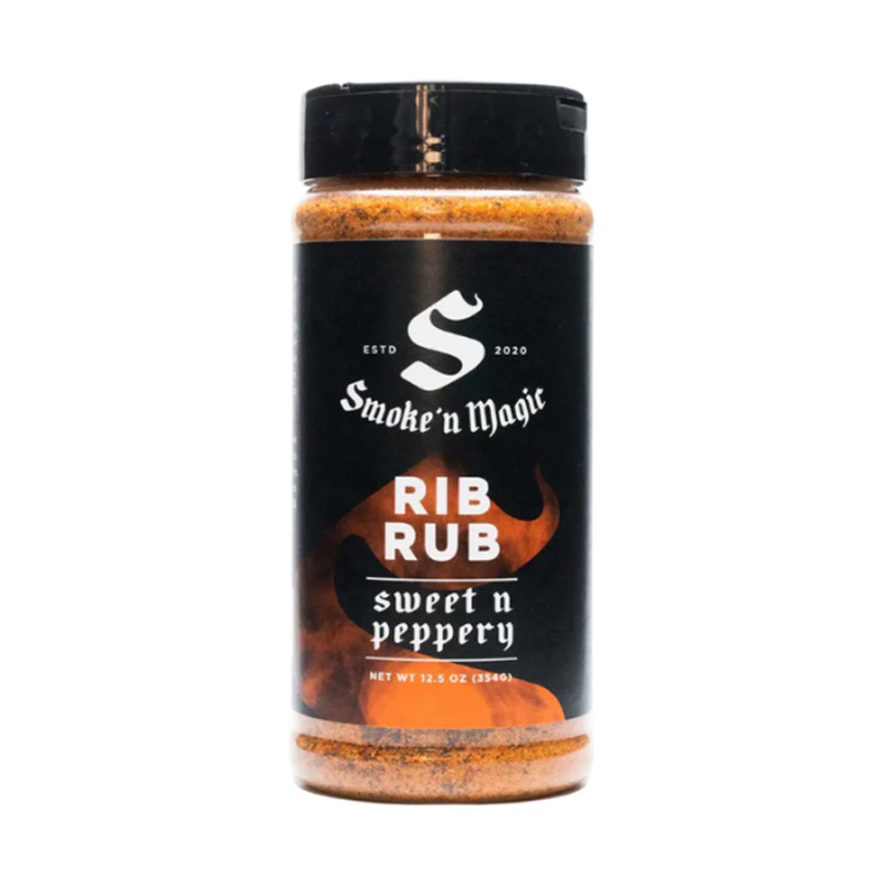 Bottle of Smoke ’N Magic Rib Rub beside smoked ribs and pulled pork