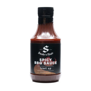 Bottle of Smoke ’N Magic Spicy BBQ Sauce beside glazed ribs and chicken wings