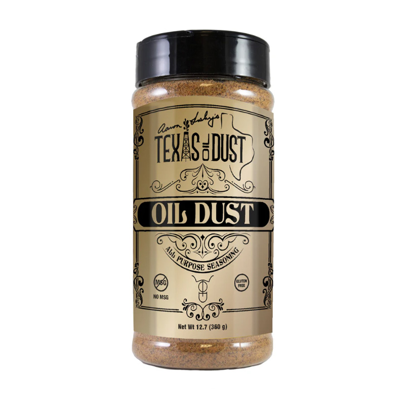 Bottle of Texas Oil Dust All Purpose Seasoning beside grilled steak and chicken