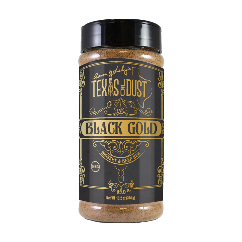 Bottle of Texas Oil Dust Black Gold Rub beside smoked brisket and ribs