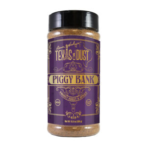 Bottle of Texas Oil Dust Piggy Bank Rub beside smoked ribs and pulled pork