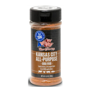Bottle of Three Little Pigs All Purpose BBQ Rub beside smoked ribs and chicken
