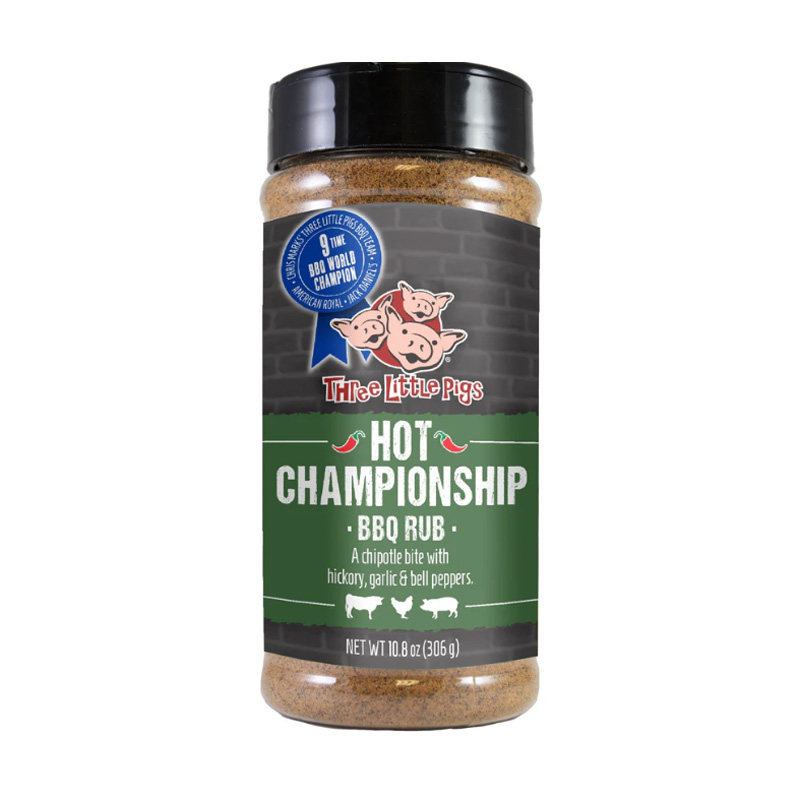Bottle of Three Little Pigs Kansas City Hot Championship BBQ Rub beside glazed ribs and chicken