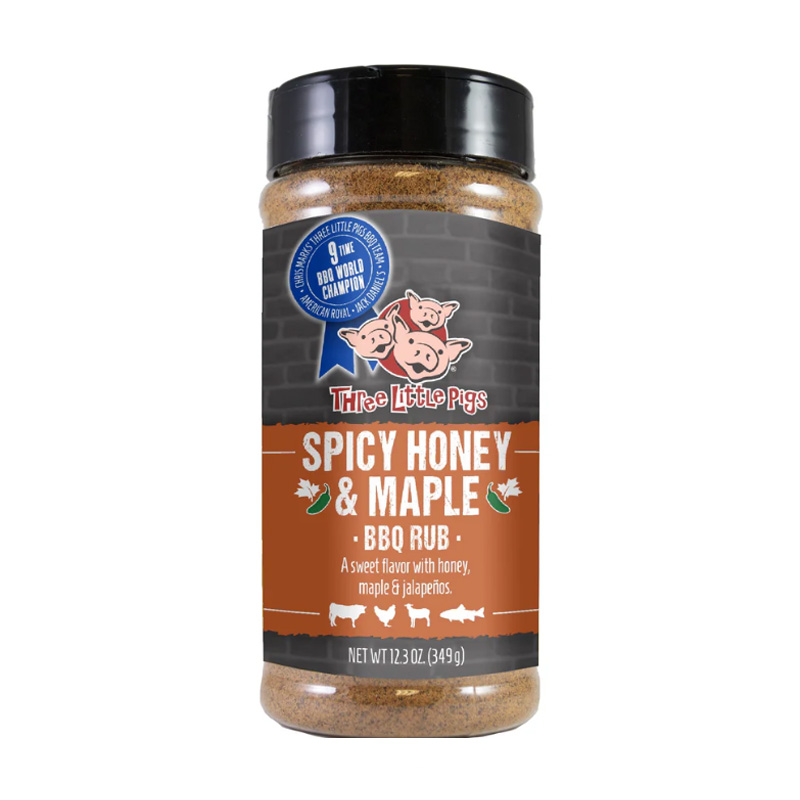 Bottle of Three Little Pigs Spicy Honey & Maple BBQ Rub beside glazed ribs and chicken