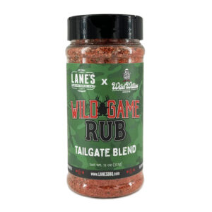 Lane’s Wild Willies Wild Game Rub jar beside grilled venison steaks and herbs.