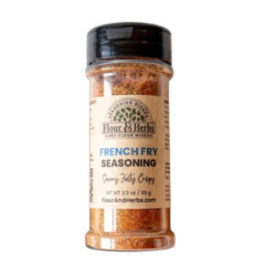 Flour & Herbs French Fry Seasoning bottle beside crispy fries and dipping sauce.