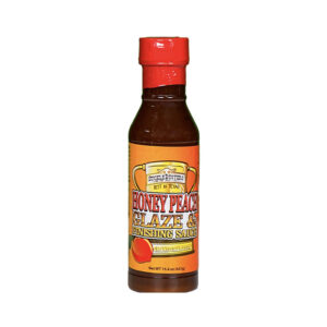 Bottle of SuckleBusters Honey Peach Glaze 15.4 oz on a wooden board