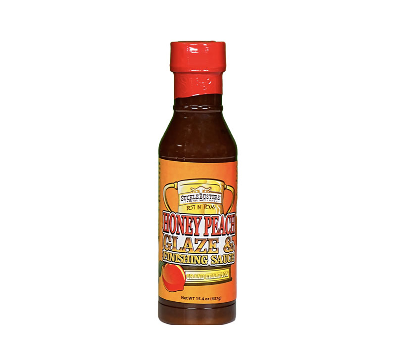 Bottle of SuckleBusters Honey Peach Glaze 15.4 oz on a wooden board