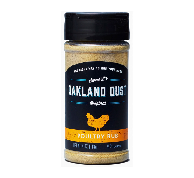 Shaker bottle of Oakland Dust Poultry Rub beside roasted chicken with golden herb crust