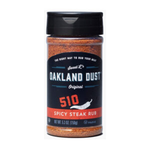 Jar of Oakland Dust 510 Spicy Steak Rub with grilled steak in background