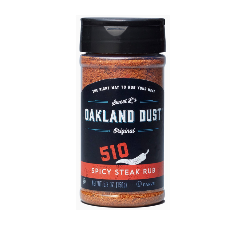 Jar of Oakland Dust 510 Spicy Steak Rub with grilled steak in background