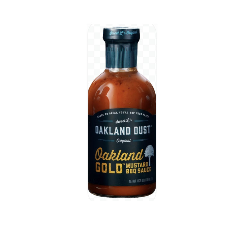 Bottle of Oakland Dust Oakland Gold Mustard BBQ Sauce beside pulled-pork sandwich topped with sauce