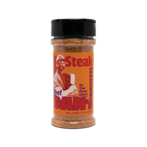 Chef Dan’s Steak Sauce Seasoning bottle beside a grilled steak and steak knife.