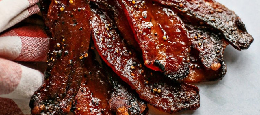 Candied bacon recipe coated in brown sugar and 1000Rubs seasoning, baked to a sweet and crispy finish.