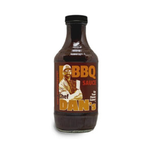 Chef Dan’s BBQ Sauce bottle beside glazed ribs and grilled chicken.