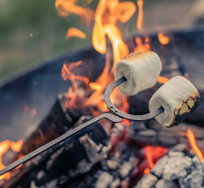 Roasting marshmallows over a campfire using a cowboy roasting stick